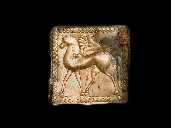 Particolare di una lamina in bronzo decorata a formelle con animali gradienti.