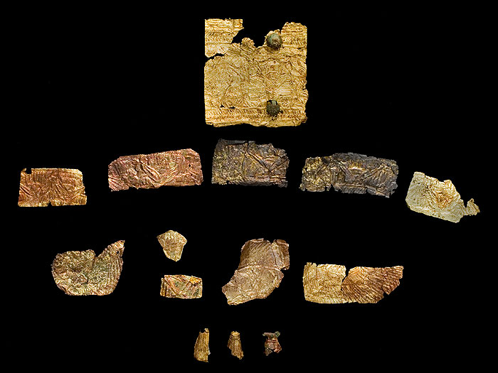 Lamine d'oro di diverse dimensioni, decorate ad impressione, e pendagli a goccia. 