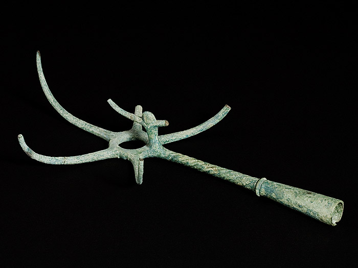 Creagra a cinque raffi con impugnatura conica, decorata a scanalature.