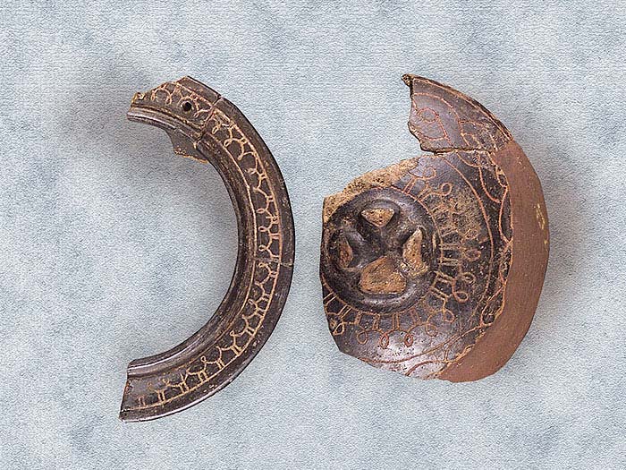  Pisside in impasto bruno con decorazione a treccia incisa.